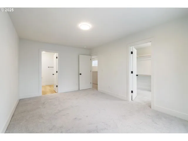 a view of an empty room with cabinet and a window
