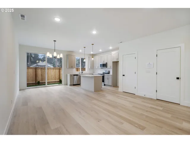 a view of a kitchen with a refrigerator kitchen island and wooden floor