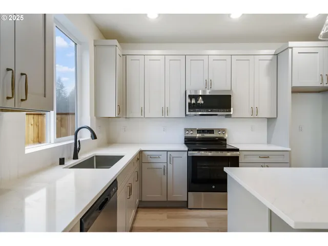 a kitchen with stainless steel appliances granite countertop a sink stove and microwave