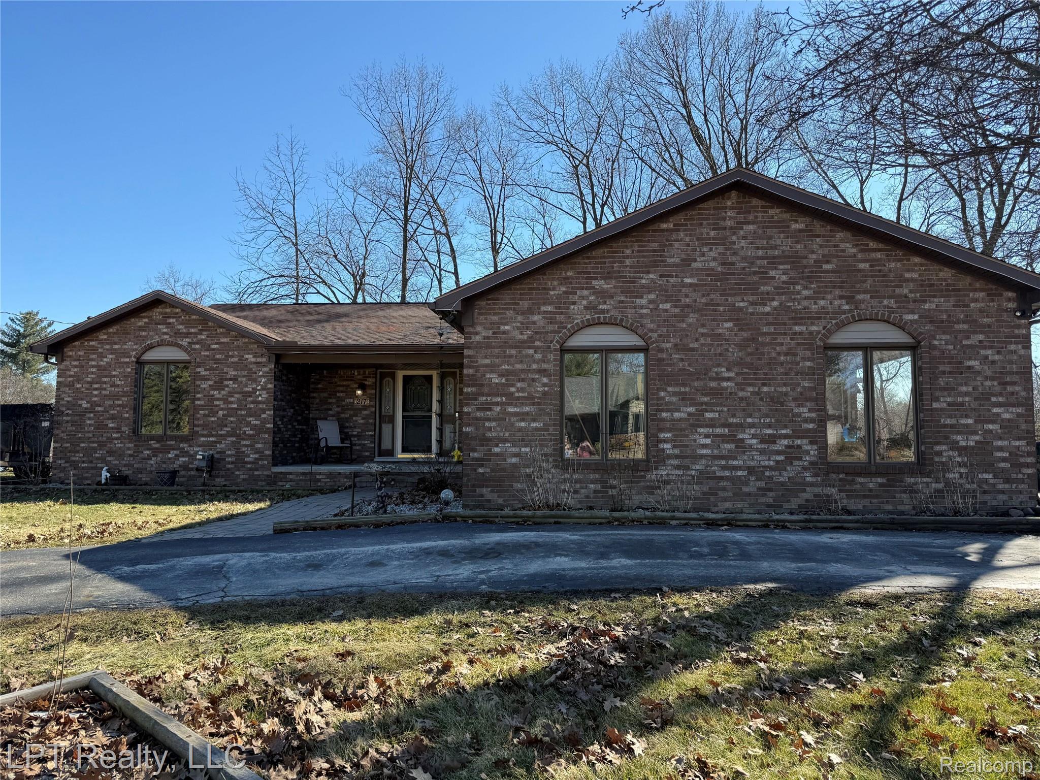 217 Nawakwa Road Rochester, MI 48307 - Photo 1 of 29 View of front of house featuring brick siding, a front yard, and covered porch