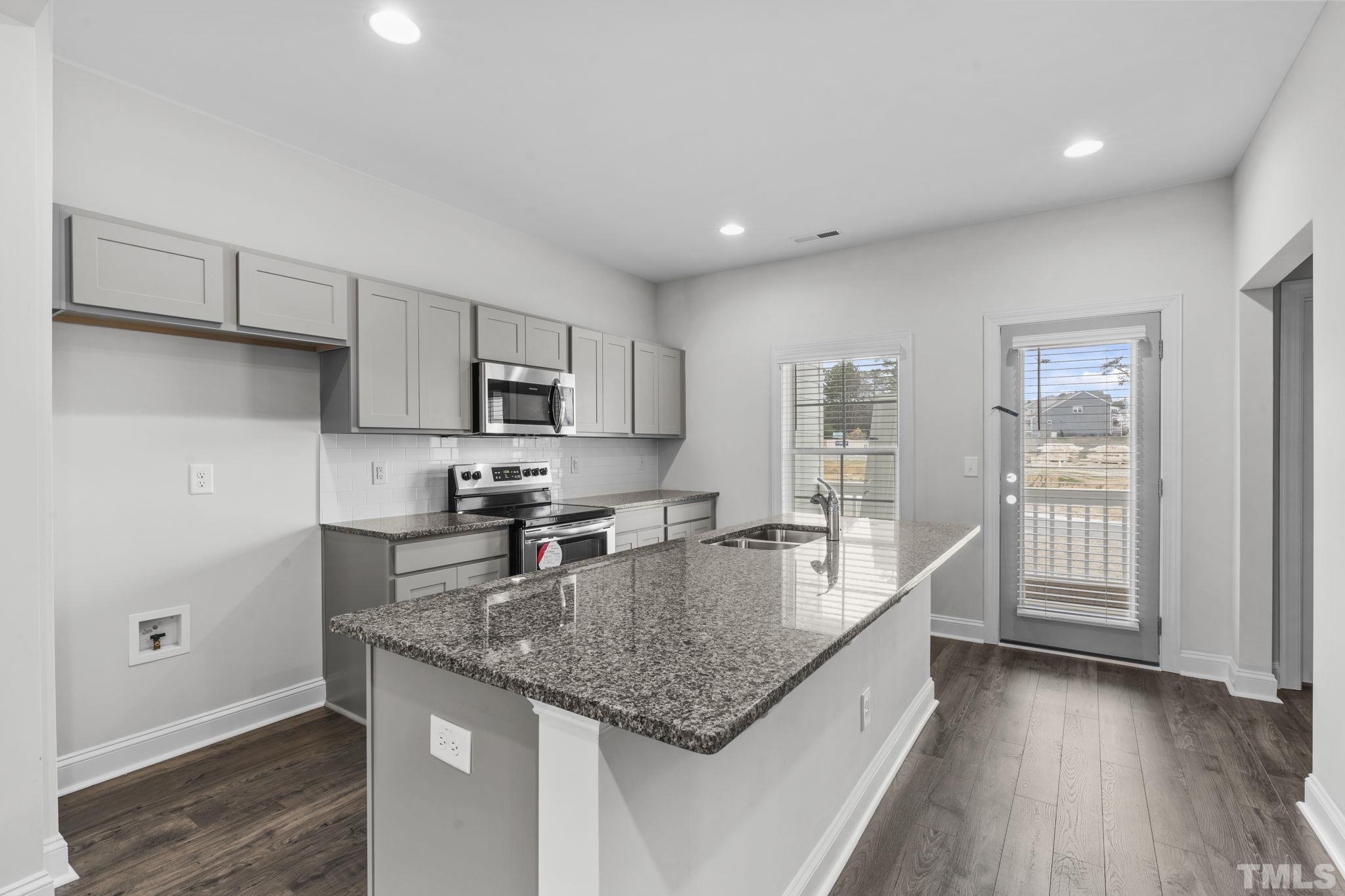 1150 Breadsell Lane Wake Forest, NC 27587 - Photo 3 of 33 a white kitchen with granite countertop a sink and dishwasher a oven with wooden floors