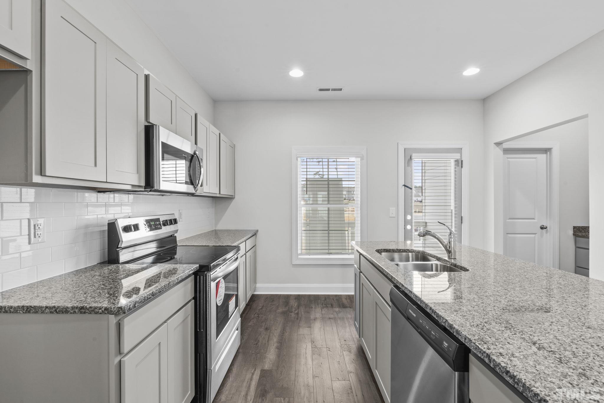 1150 Breadsell Lane Wake Forest, NC 27587 - Photo 5 of 33 a kitchen with granite countertop stainless steel appliances window a sink and cabinets