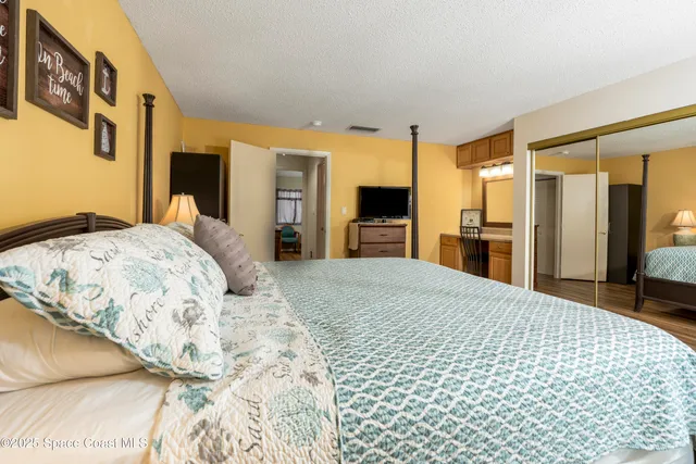 a bedroom with a bed dresser and a large window