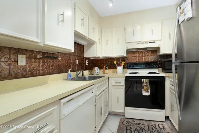 a kitchen with stainless steel appliances a stove a sink and a refrigerator
