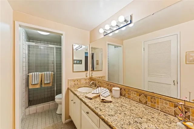 a spacious bathroom with a granite countertop sink mirror and shower