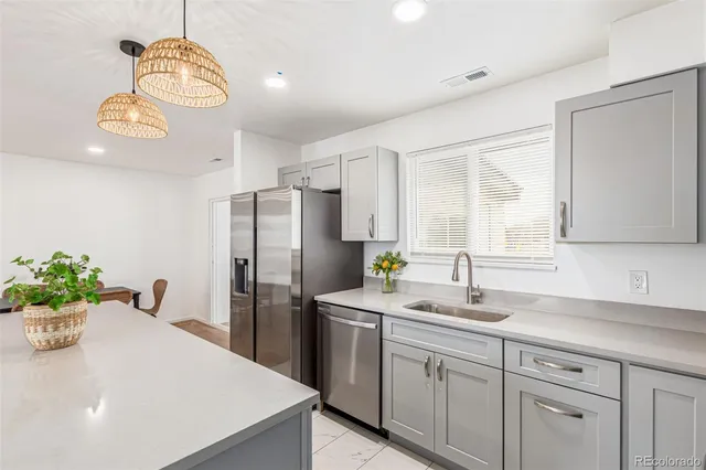 a kitchen with a refrigerator a sink cabinets and a window