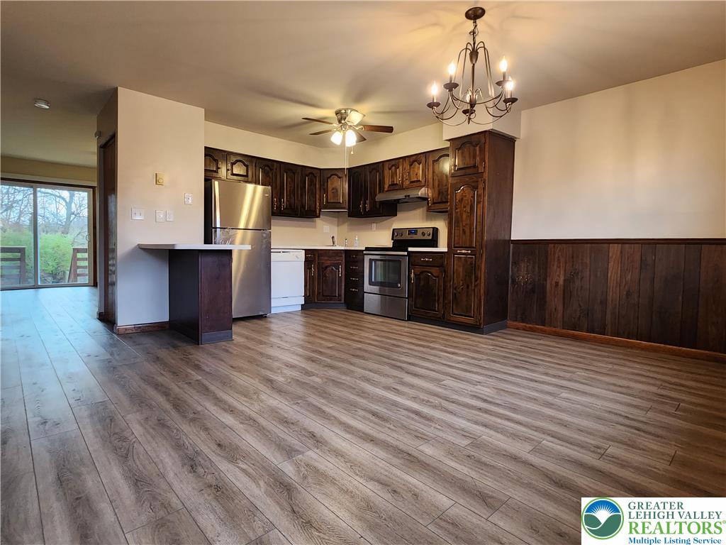 614 East Main Street Bath, PA 18014 - Photo 5 of 8 a large kitchen with stainless steel appliances granite countertop a refrigerator a stove top oven a sink dishwasher and wooden floor