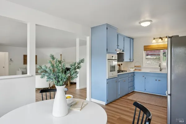 a kitchen with stainless steel appliances granite countertop a dining table chairs and granite counter tops