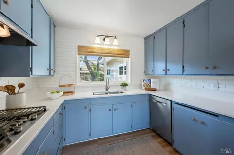 a kitchen with a sink stove top oven and cabinets