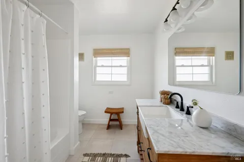 a bathroom with a granite countertop sink a toilet and a bathtub
