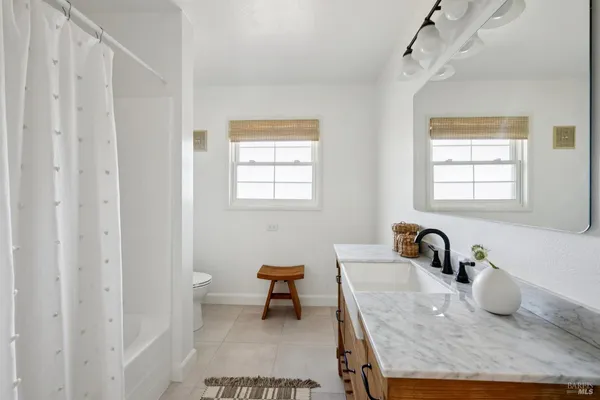 a bathroom with a granite countertop sink a toilet and a bathtub