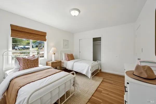 a bedroom with two beds and a large window