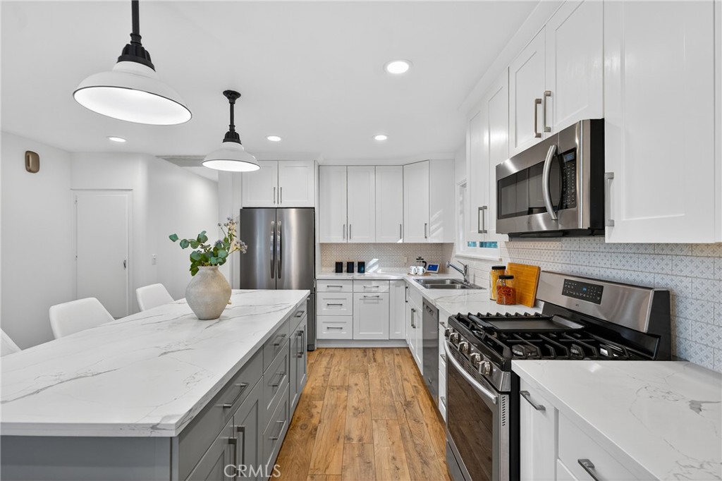 7576-7582 McGroarty Terrace Los Angeles, CA 91042 - Photo 34 of 47 a kitchen with a stove a sink and a refrigerator