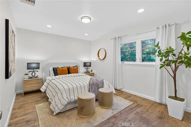 a bedroom with a bed and a potted plant