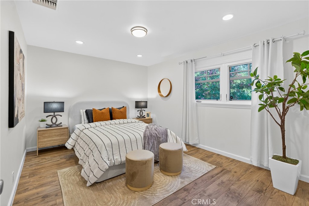 7576-7582 McGroarty Terrace Los Angeles, CA 91042 - Photo 39 of 47 a bedroom with a bed and a potted plant