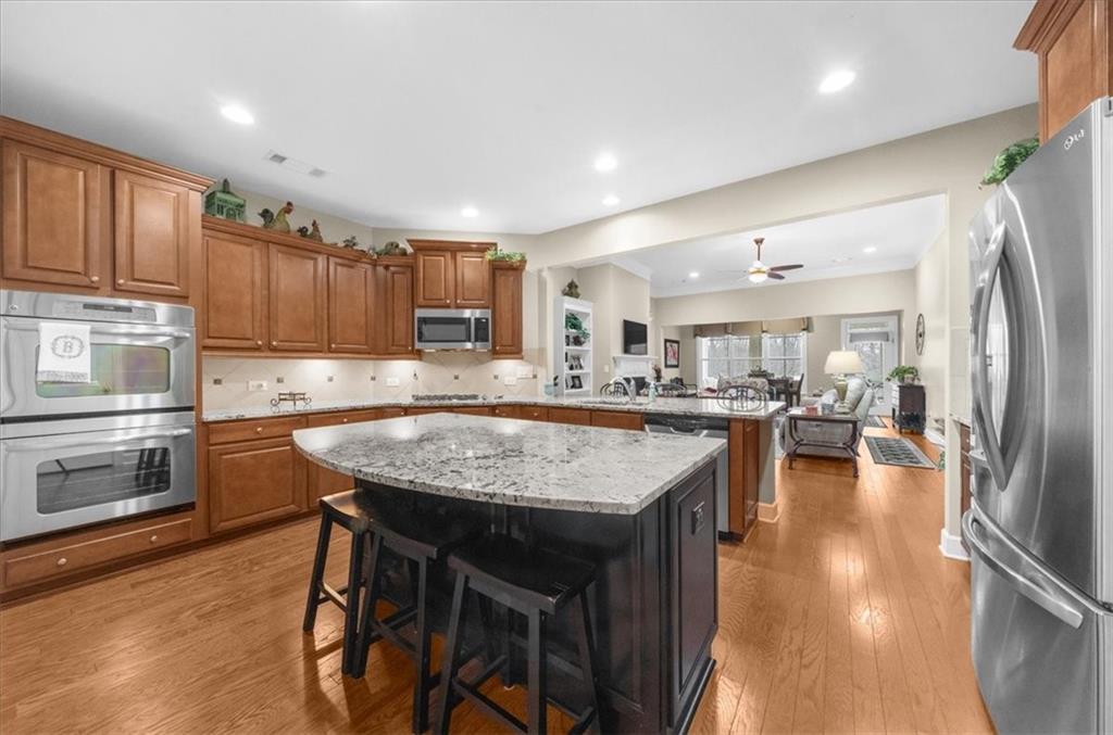 3357 Locust Cove Road Gainesville, GA 30504 - Photo 12 of 77 a kitchen with stainless steel appliances granite countertop a table chairs sink refrigerator and microwave