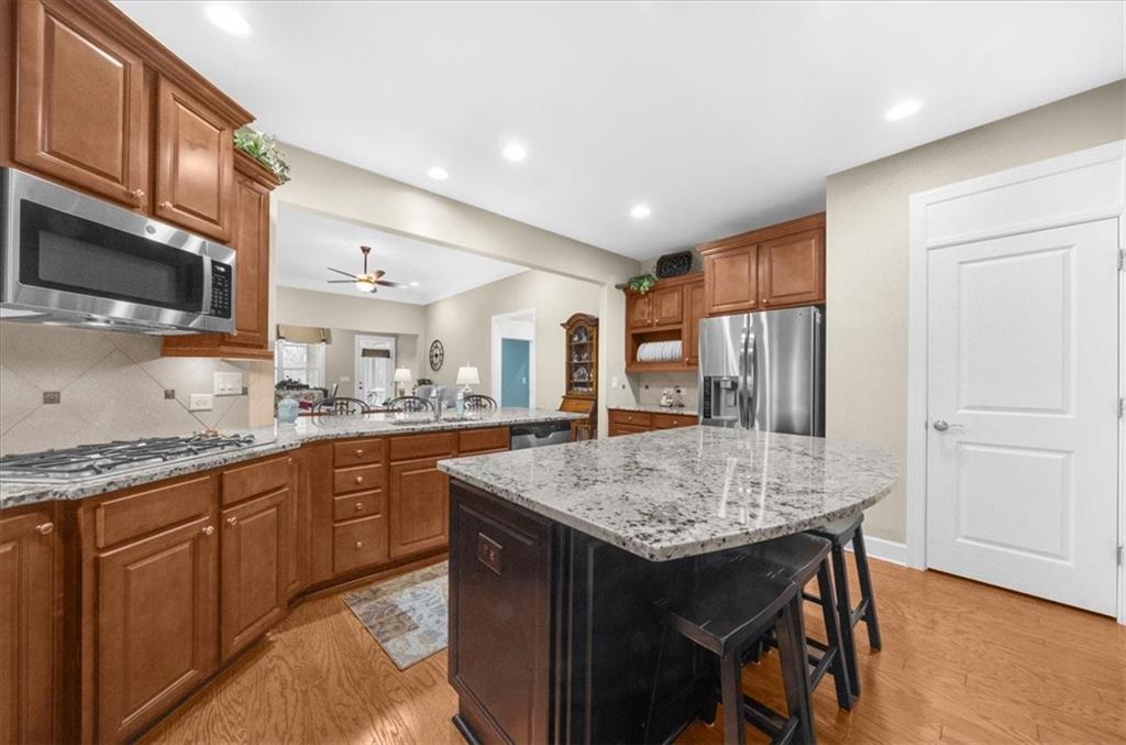 3357 Locust Cove Road Gainesville, GA 30504 - Photo 13 of 77 a kitchen with stainless steel appliances granite countertop wooden cabinets a center island and a refrigerator