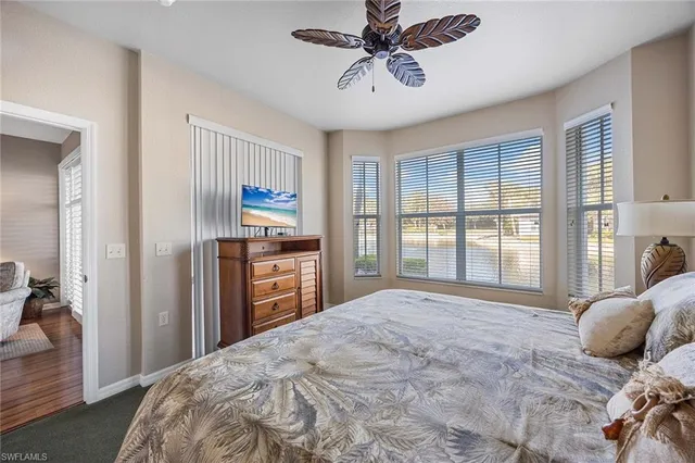 a bedroom with a large bed and a flat tv screen