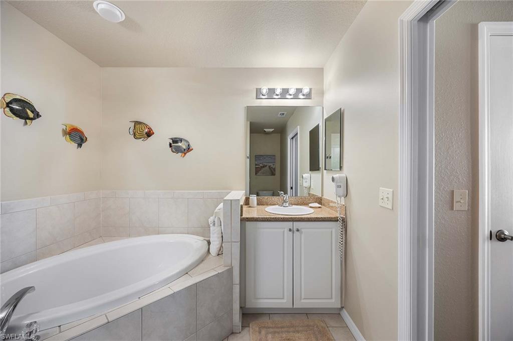 Undisclosed Address Naples, FL 34113 - Photo 15 of 38 a bathroom with a bathtub and a sink