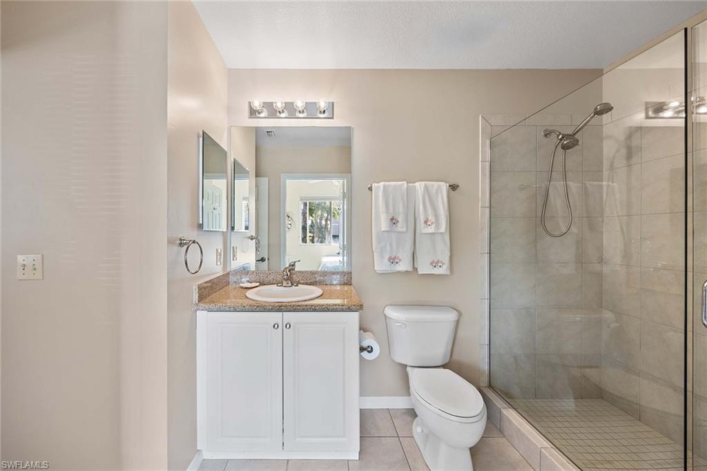 Undisclosed Address Naples, FL 34113 - Photo 18 of 38 a bathroom with a toilet a sink and a mirror