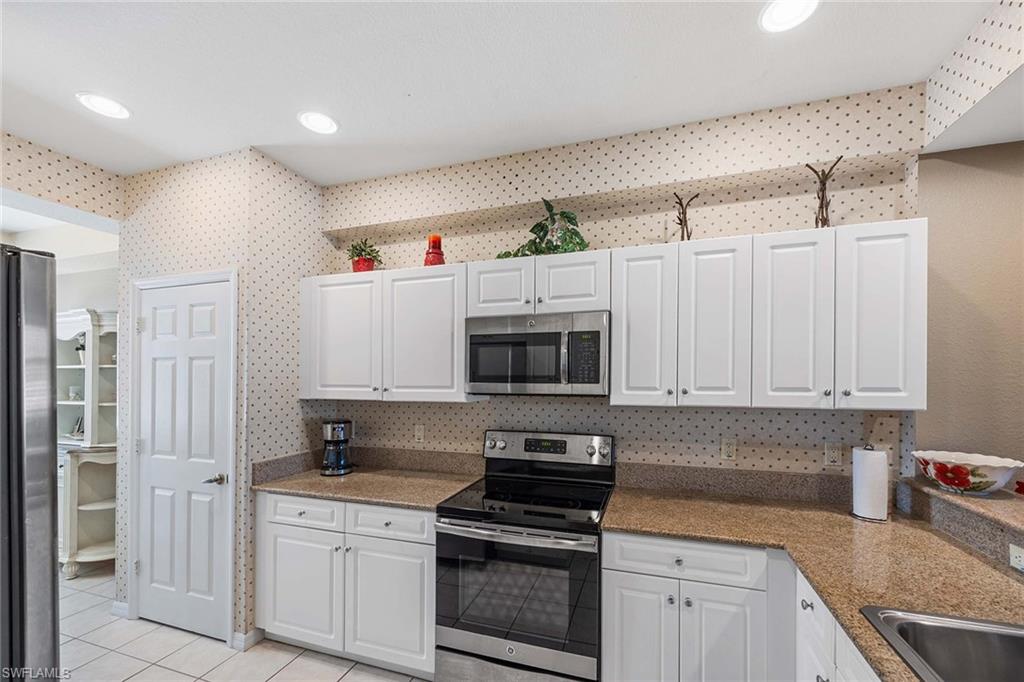 Undisclosed Address Naples, FL 34113 - Photo 7 of 38 a kitchen with granite countertop a stove and a sink