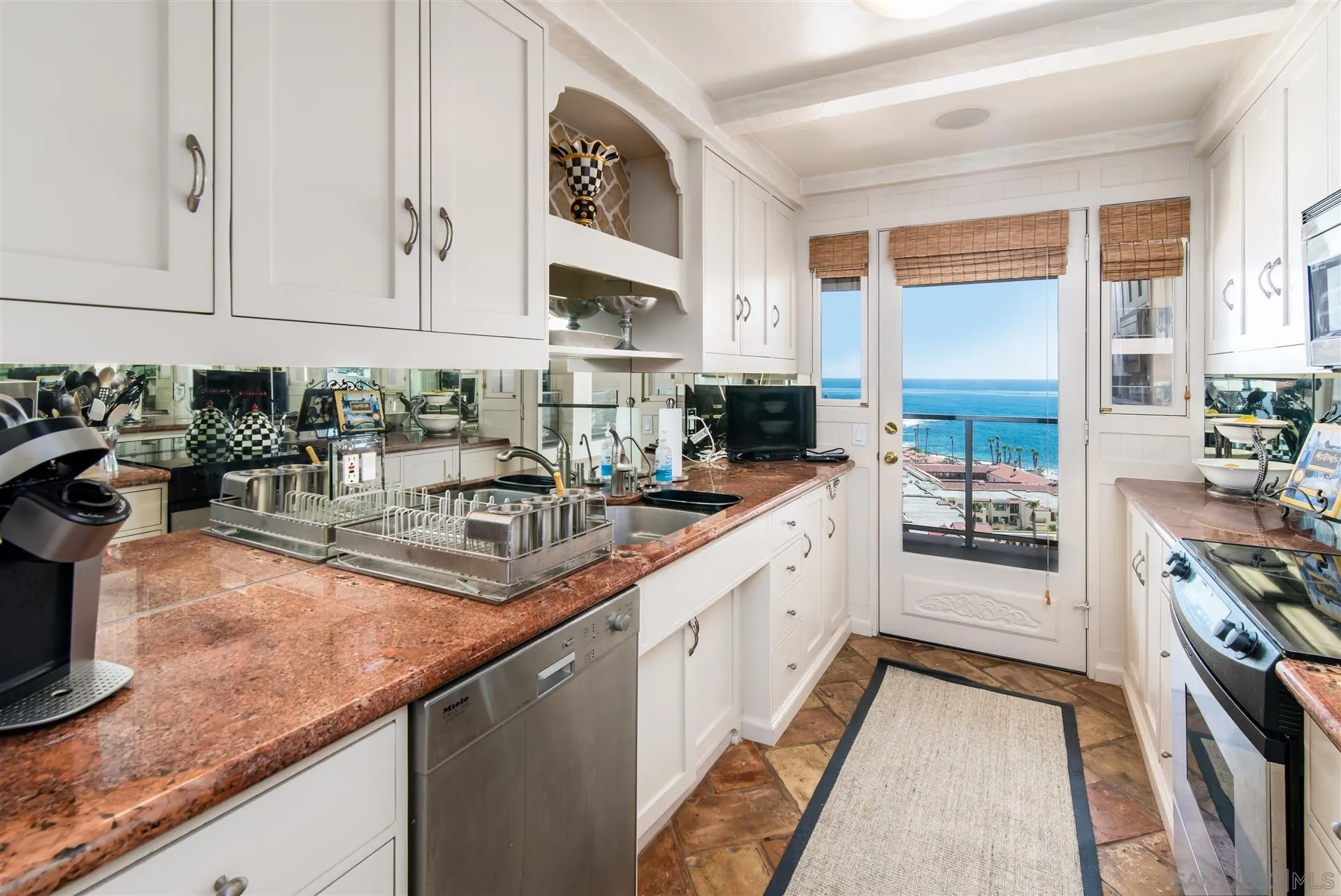 939 Coast Boulevard, Unit 16F La Jolla, CA 92037 - Photo 8 of 22 a kitchen with stainless steel appliances granite countertop a sink stove and cabinets