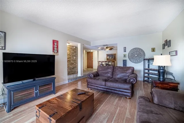 a living room with furniture a flat screen tv and a window
