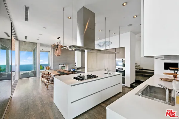 a kitchen that has a stove a table and chairs in it