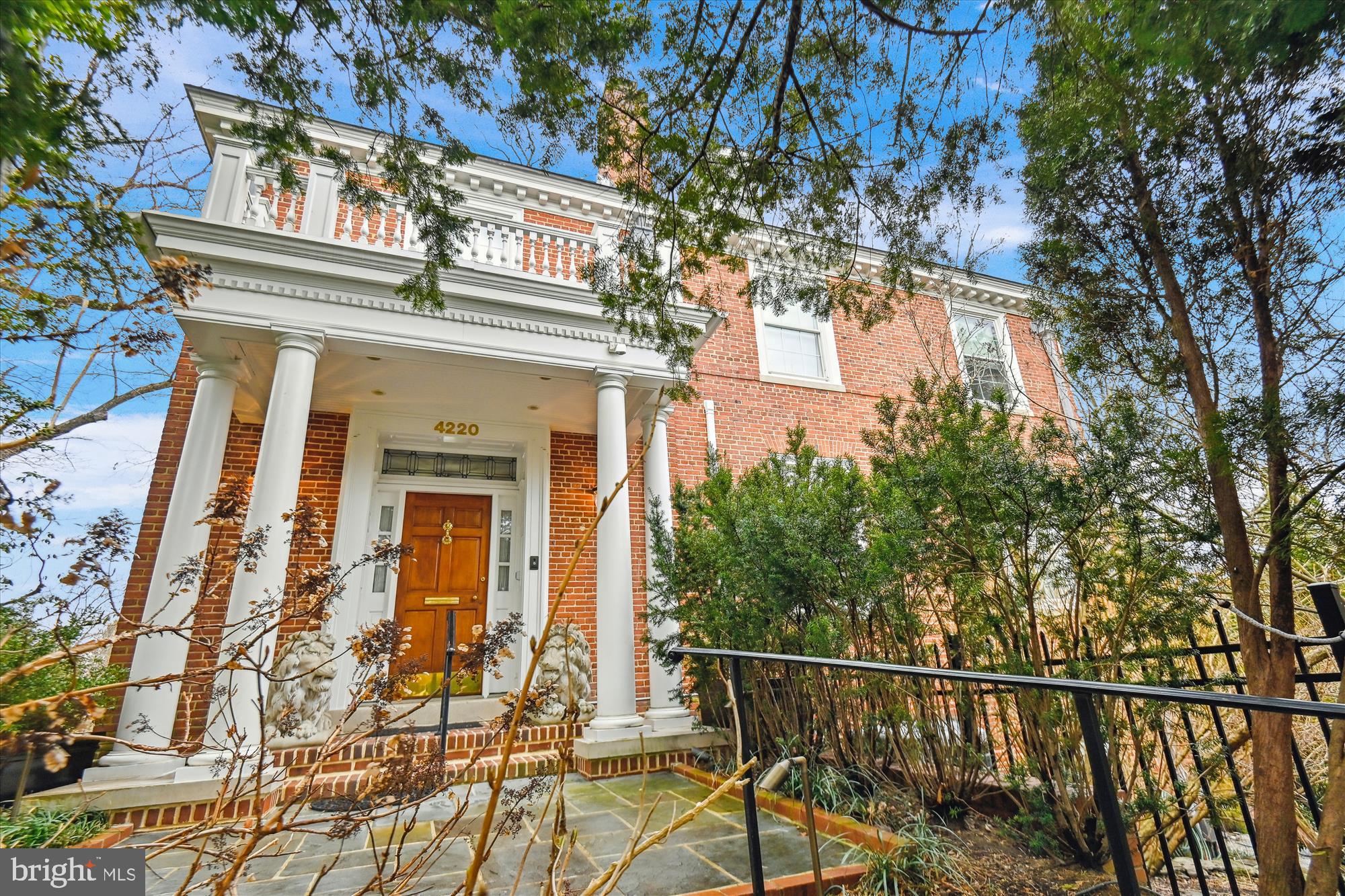 a view of a brick house with large windows and a tree