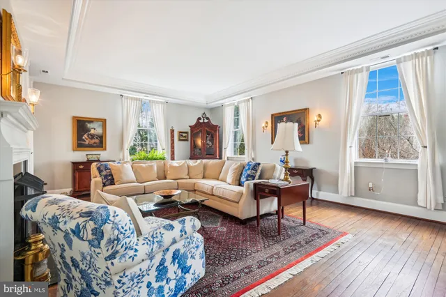 a living room with furniture large window and wooden floor