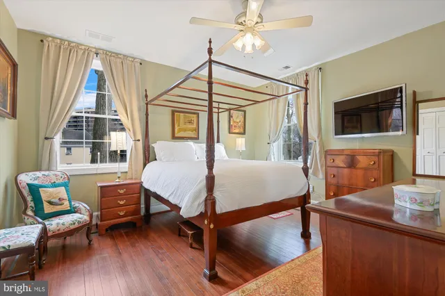 a bedroom with a bed window and a flat screen tv