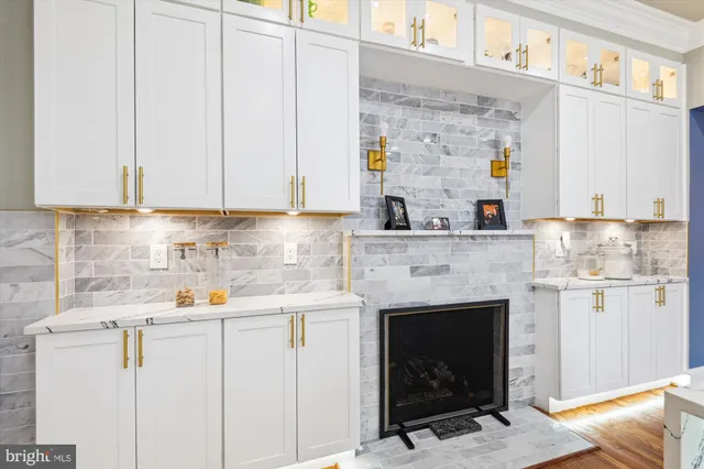 a kitchen with stainless steel appliances granite countertop a fireplace a stove and white cabinets