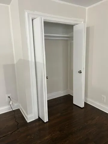an empty room with wooden floor and closet