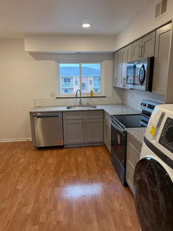 a kitchen with stainless steel appliances granite countertop a stove a sink and a microwave