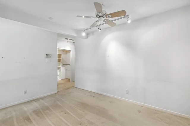 an empty room with a ceiling fan and a window