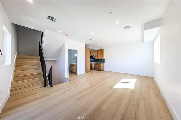 a view of empty room with wooden floor