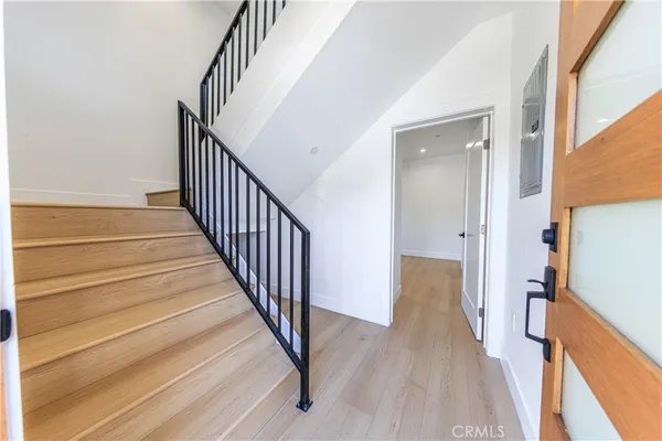 a view of a hallway with wooden floor and staircase