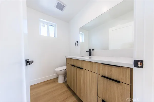 a bathroom with a double vanity sink toilet and a mirror