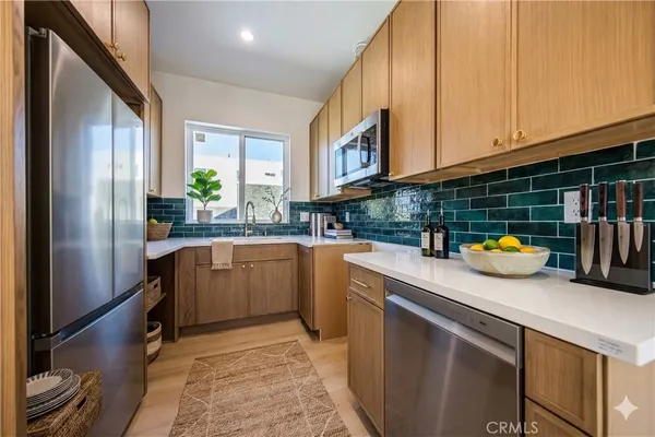 a kitchen with stainless steel appliances a sink a counter top space and cabinets