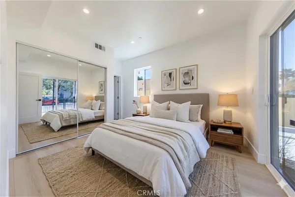 a bedroom with a bed and a large mirror