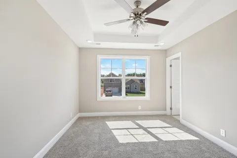 an empty room with windows and fan