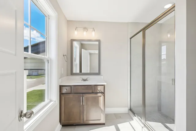 a bathroom with a granite countertop sink a mirror and shower
