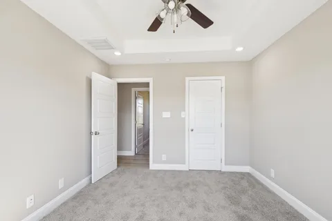 an empty room with chandelier fan