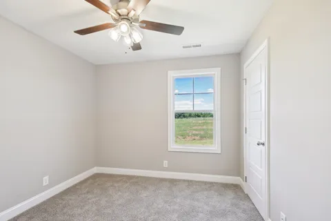 an empty room with a window and a fan