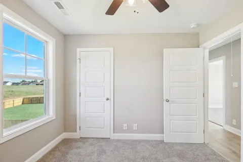 an empty room with windows and closet