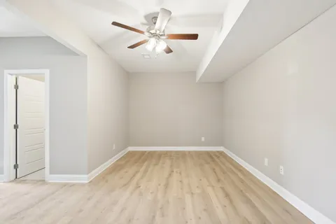 an empty room with a ceiling fan and carpet