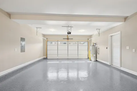 a view of an empty room with window and chandelier fan