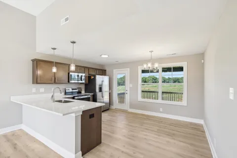 a kitchen with kitchen island a sink stove and wooden floor