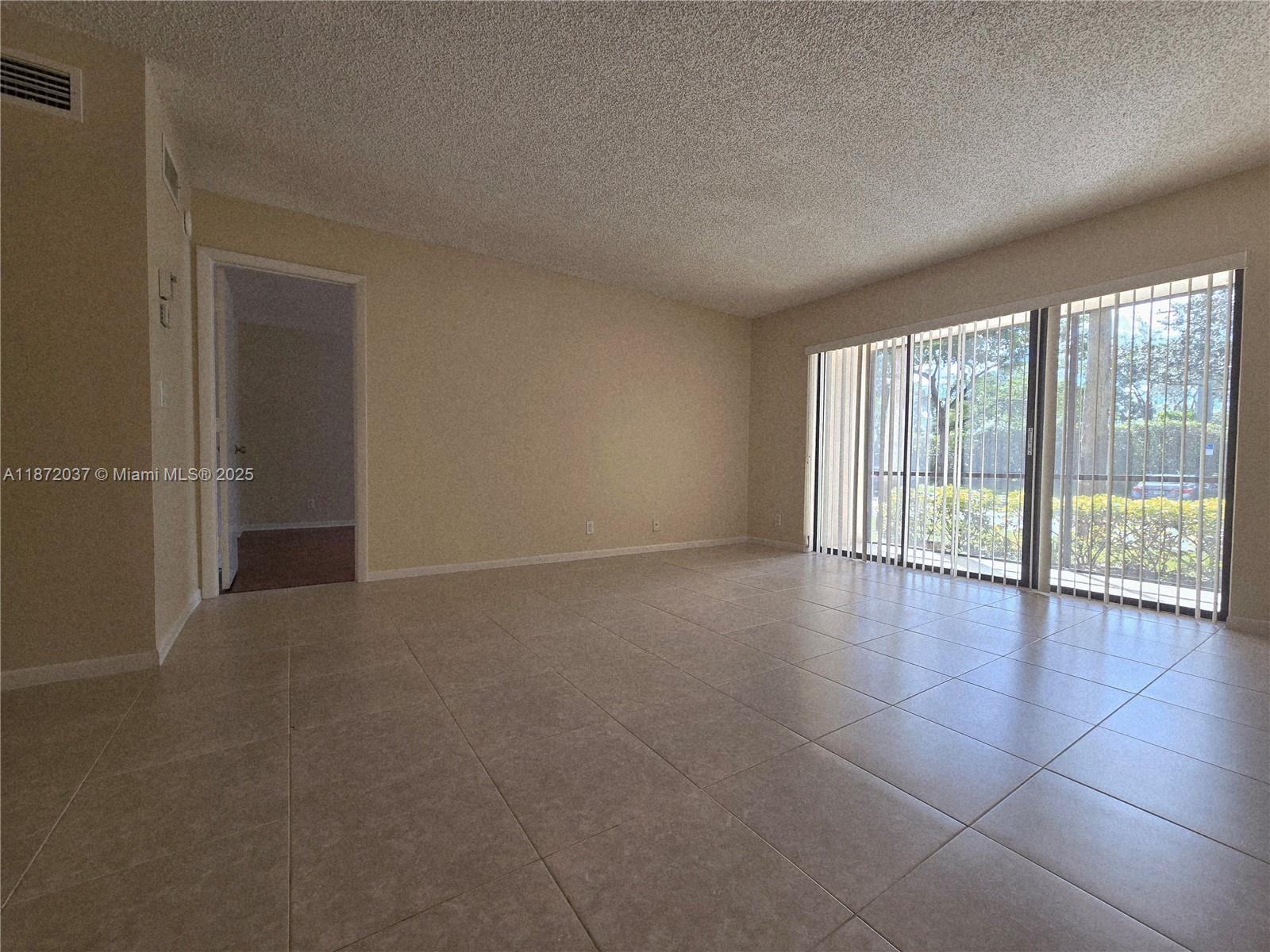 204 Foxtail Drive, Unit D1 Greenacres, FL 33415 - Photo 3 of 12 an empty room with wooden floor and windows