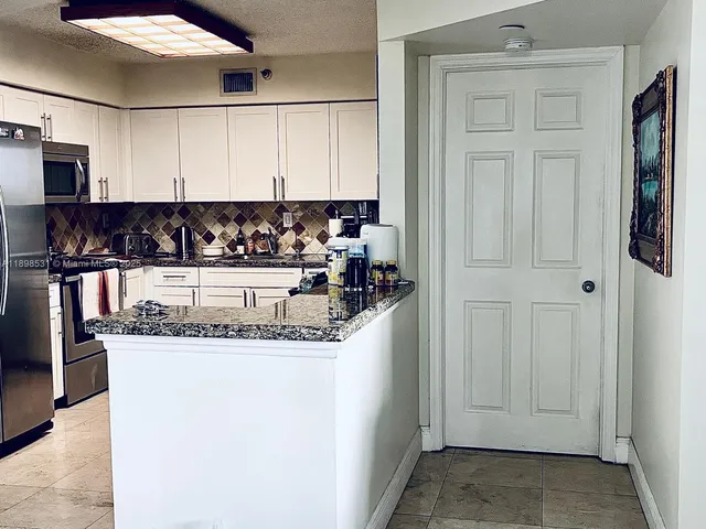 a kitchen with stainless steel appliances granite countertop a sink and cabinets